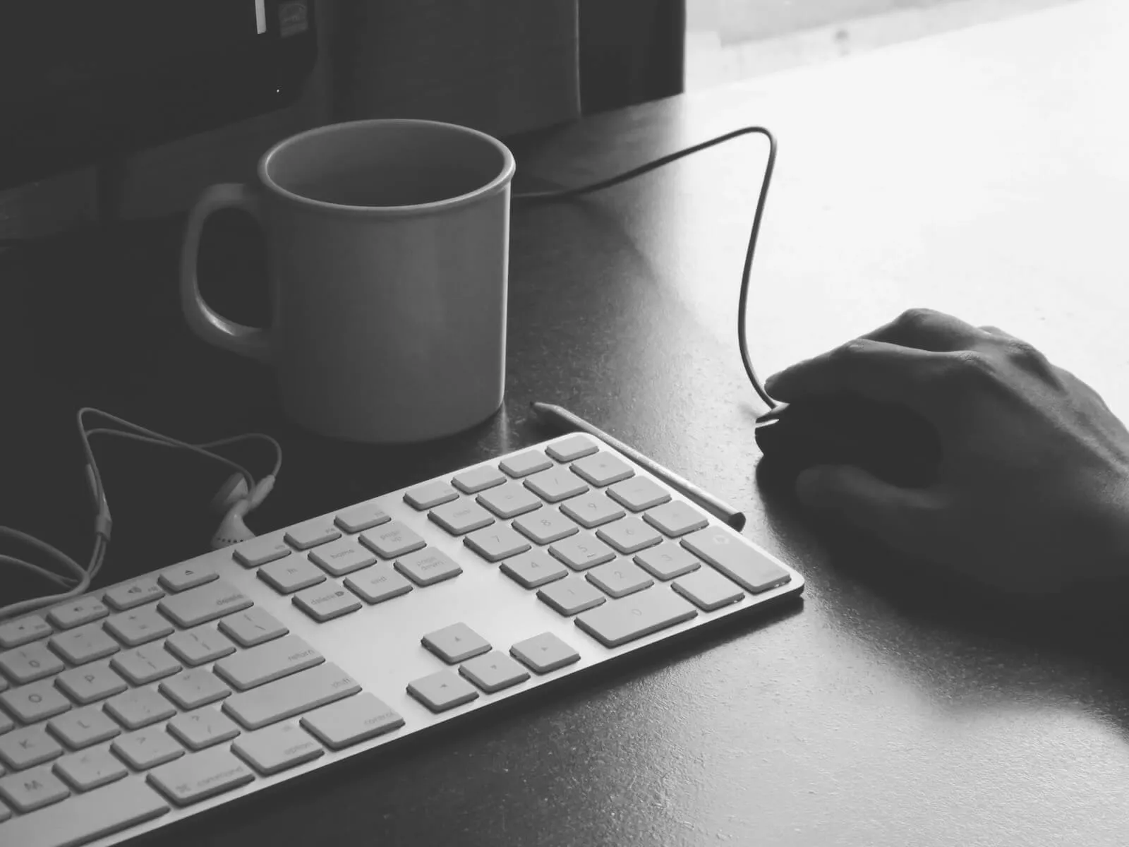 Teclado y taza de café en un escritorio